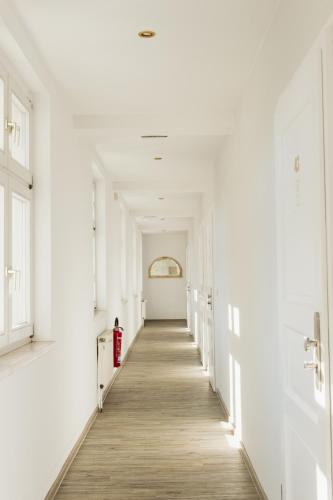 a hallway with white walls and a wooden floor at Hotel & Restaurant "Deutscher Kaiser" in Perleberg