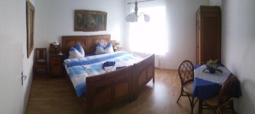 a bedroom with a bed and a table and a window at Vila Patricie in Luhačovice