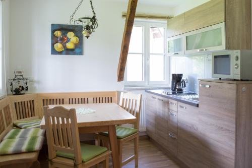 a kitchen with a table and chairs and a microwave at Buschenschank Ofnerpeter in Greisdorf