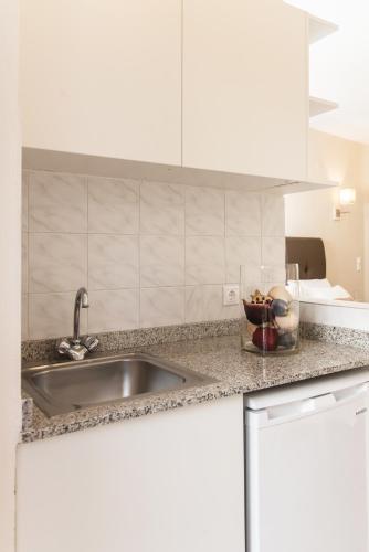 a kitchen counter with a sink and a bowl of fruit at Mirage Studios in Malia