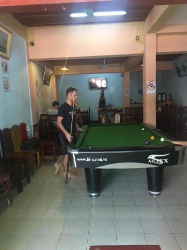 a man standing next to a pool table at Dream Home Hostel in Vientiane
