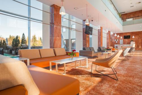 an office lobby with couches and tables and windows at Premier Kraków Hotel in Kraków