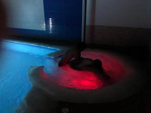 a person sitting on a red circle in a room at Casa con Piscina Privada y Jacuzzi in Flandes
