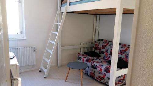 sypialnia z łóżkiem piętrowym, kanapą i drabiną w obiekcie Studio 4 personnes w mieście La Mongie