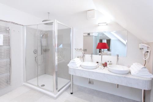 a bathroom with two sinks and a shower at Lesar Hotel Angel - Member of Hip Hotels in Ljubljana