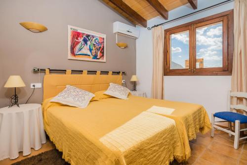 una camera con letto giallo e finestra di Villa Cas Bujarro By SunVillas Mallorca a Pollença