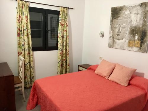 una camera con letto rosso e finestra di Mirador del Mar a Puerto del Carmen