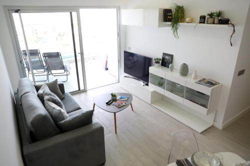 a living room with a couch and a tv at Luxury apartment in Playa Paraiso in Playa Paraiso