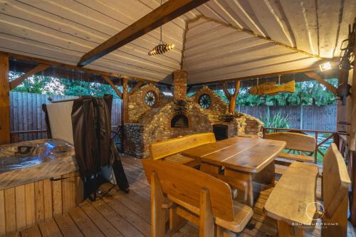 an outdoor patio with a table and a stone oven at The Retreat Sauna & Hot Tub Boutique Rooms in Great Paxton