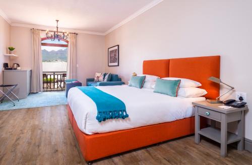 a bedroom with a large bed and a desk at De Zalze Lodge in Stellenbosch