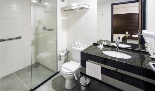 a bathroom with a toilet and a sink and a shower at Ritz Suites Lifestyle in Maceió