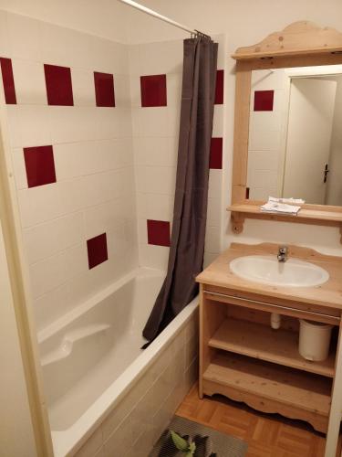 une salle de bain avec une baignoire, un lavabo et un miroir dans l'établissement Appartement 4/6 personnes Puy Saint Vincent, à Puy-Saint-Vincent