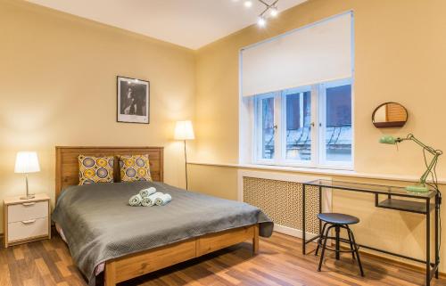 um quarto com uma cama, uma secretária e uma janela em Charming spacious 3 bedroom in Old Town em Riga