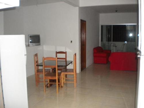 sala de estar con mesa, sillas y sofá rojo en Paraíso em Cacoes, en Jaguaribe