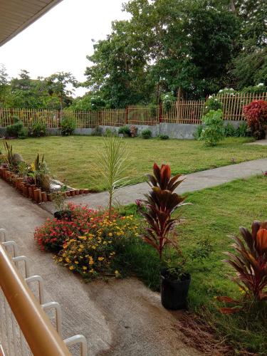 a garden with many plants and a fence at Uptown Guesthouse in Siquijor