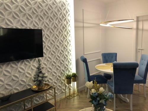 a living room with a tv on a wall at Family & Business Sauna Apartments No2 Leśny nad Zalewem Cedzyna - 2 Bedroom with Private Sauna, Bath with Hydromassage, Terrace, Parking, Catering Options in Kielce