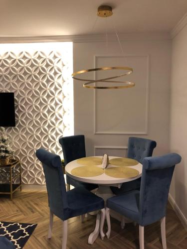 a dining room with a table and blue chairs at Family & Business Sauna Apartments No2 Leśny nad Zalewem Cedzyna - 2 Bedroom with Private Sauna, Bath with Hydromassage, Terrace, Parking, Catering Options in Kielce