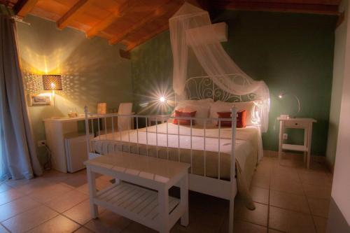 a bedroom with a white bed and a table at Country Resort Le Due Ruote in Alberese