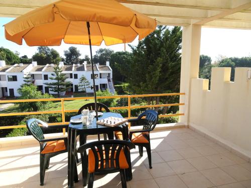 a table and chairs with an umbrella on a balcony at Copacabana by Check-in Portugal in Vilamoura