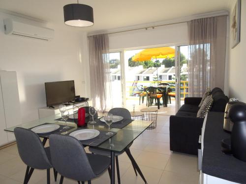 a dining room and living room with a table and chairs at Copacabana by Check-in Portugal in Vilamoura