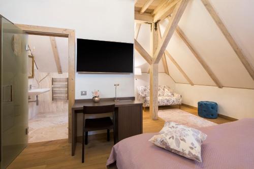 a bedroom with a desk and a tv on the wall at Kaštieľ Kubínyi in Dolný Kubín
