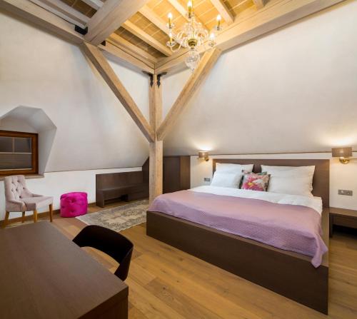 a bedroom with a large bed and a table at Kaštieľ Kubínyi in Dolný Kubín