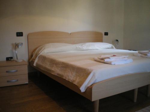 a bedroom with a large bed with towels on it at Ai Vellutai in Ala