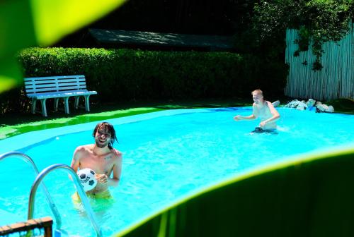 two men playing with a soccer ball in a swimming pool at Wiki Hostel Colive in Zagarolo
