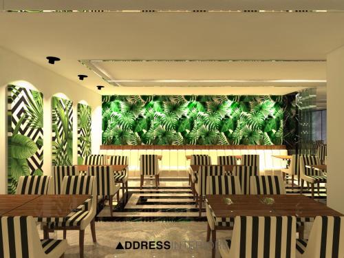 a restaurant with tables and chairs and a green wall at Kavala Hotel in Bursa