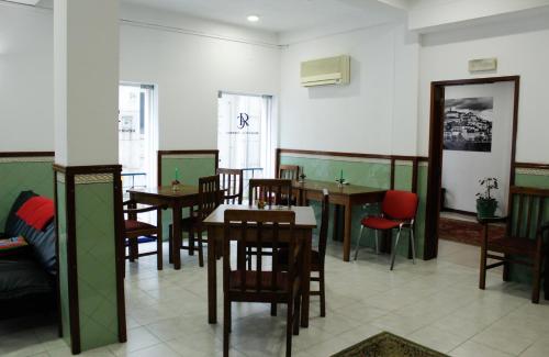 a dining room with wooden tables and chairs at Residencia Coimbra in Coimbra