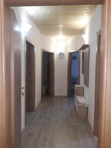 un pasillo con 2 puertas y una habitación con suelo de madera en ATL AGRITURISMO, en Salorno