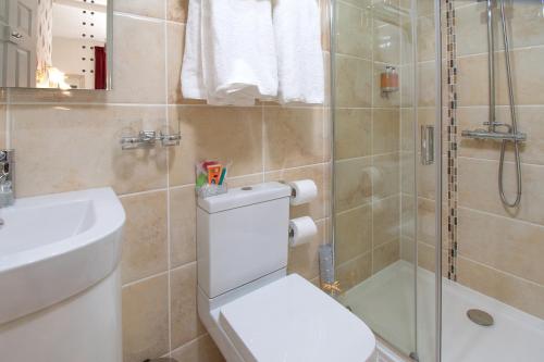 a bathroom with a toilet and a shower and a sink at The Kendrick Exclusively for adults in Llandudno