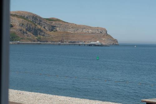 a green buoy in the water next to a mountain at The Kendrick Exclusively for adults in Llandudno