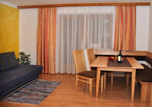 ein Wohnzimmer mit einem Tisch und einem Sofa in der Unterkunft Appartementhaus Fuchs Christian in Westendorf