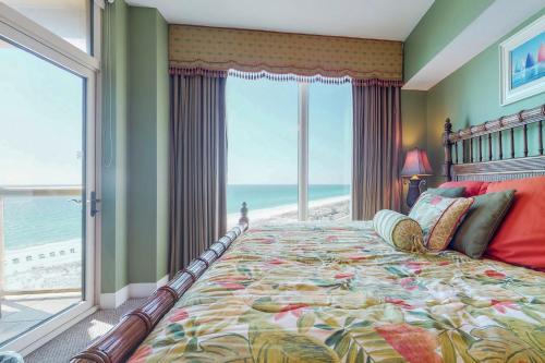 a bedroom with a bed with a view of the ocean at Portofino #1103 in Pensacola Beach