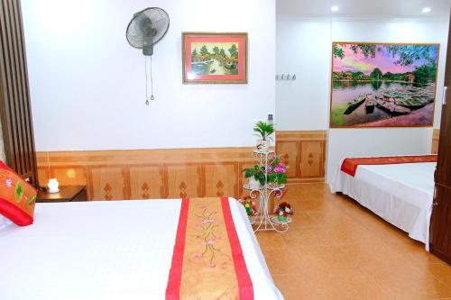 a hotel room with two beds and a fan at Xuan Hoa Hotel in Ninh Binh