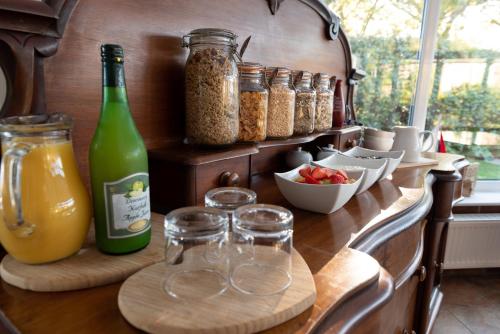 un comptoir avec des verres, des bocaux et une bouteille de nourriture dans l'établissement Armeria, à Wells-next-the-Sea