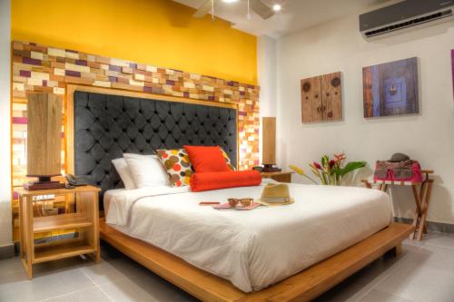 a bedroom with a large bed with orange pillows at Casa de Leda, a Kali Hotel in Santa Marta