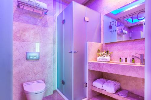 a pink bathroom with a toilet and a shower at Porto Marine Hotel in Platamonas