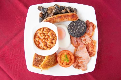 a plate of breakfast food with eggs beans and bacon at The Kendrick Exclusively for adults in Llandudno