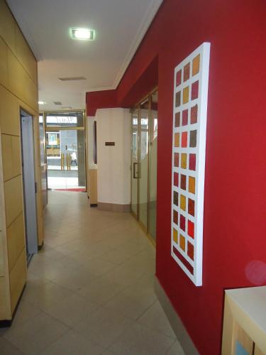 a hallway in a building with a red wall at Hotel Altiana in Ourense