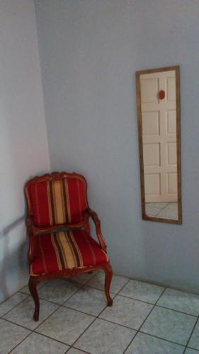 uma cadeira vermelha sentada num quarto com um espelho em Don Santiago Guesthouse Downtown em San Ignacio