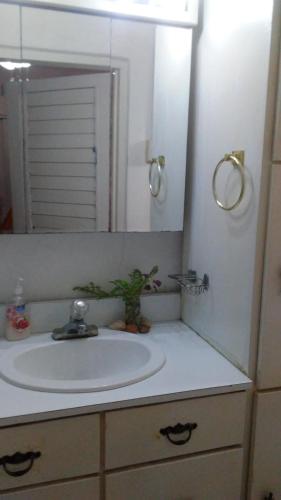 a bathroom with a sink and a mirror at Don Santiago Guesthouse Downtown in San Ignacio