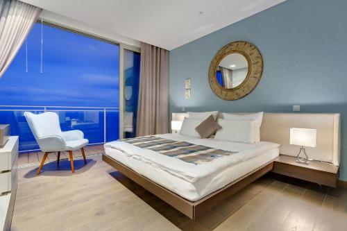 a bedroom with a bed and a chair and a mirror at Super Luxury Apartment in Tigne Point, Amazing Ocean Views in Sliema