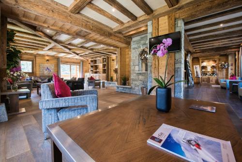 - un salon avec une table et des chaises en bois dans l'établissement CGH Résidences & Spas Le Jhana, à Tignes
