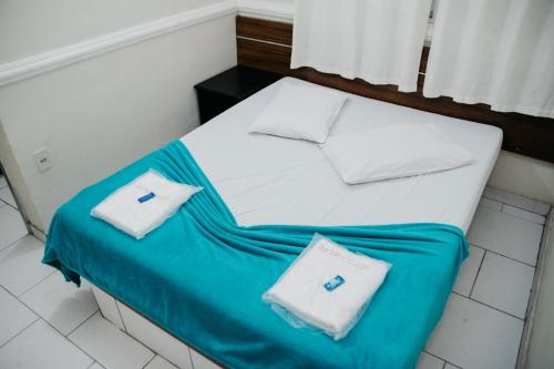 a bed with two pillows on top of it at Hotel Lumem Taguatinga Sul in Taguatinga
