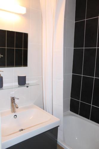 une salle de bain blanche avec un lavabo et une douche dans l'établissement L'Enclave, aux Contamines-Montjoie