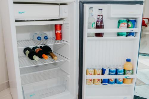 an open refrigerator filled with drinks and condiments at Hotel Lumem Taguatinga Sul in Taguatinga