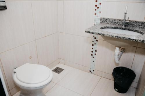 a bathroom with a toilet and a sink at Hotel Lumem Taguatinga Sul in Taguatinga