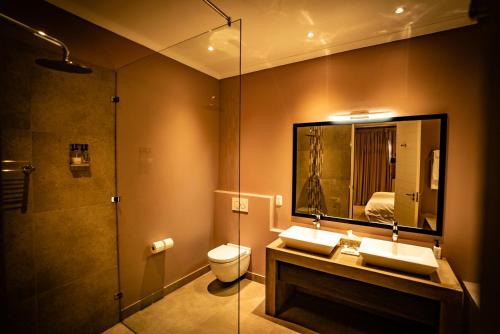 a bathroom with two sinks and a shower and a toilet at The Royal Hotel in Riebeek-Kasteel